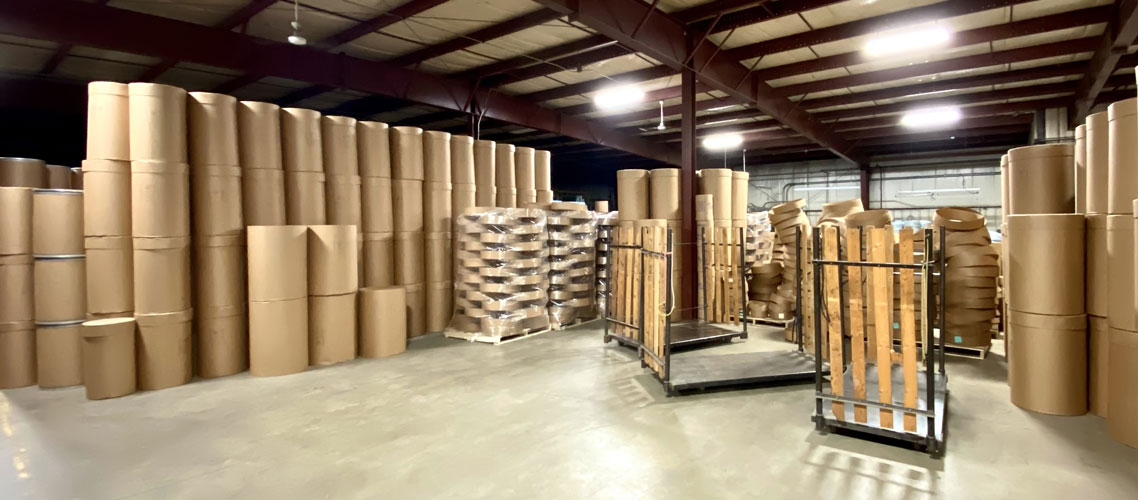 corner view of warehouse with fibre barrels and pallets ready to ship The Master Package Fibre Shipping Containers