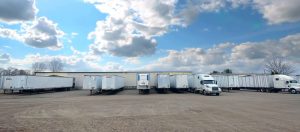 several Master Trucking trucks loading up materials to deliver to customers The Master Package Fibre Shipping Containers
