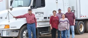 The Master Package Fibre Shipping Container family standing near semi truck