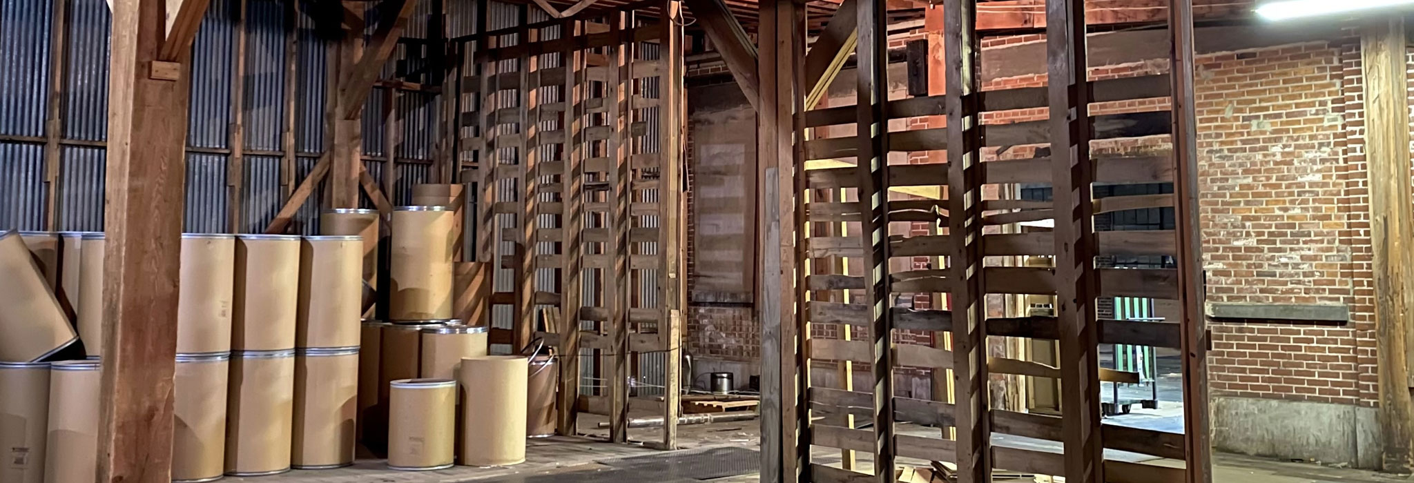 barn-like warehouse with empty shipping barrels at The Master Package Fibre Shipping Containers